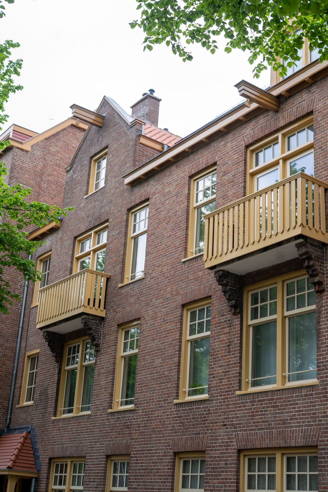 Gerenoveerde gevel met houten balkons en geschilderde kozijnen